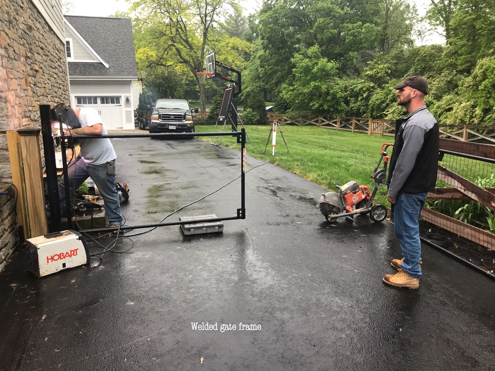 A professional technician repairing a swing gate
