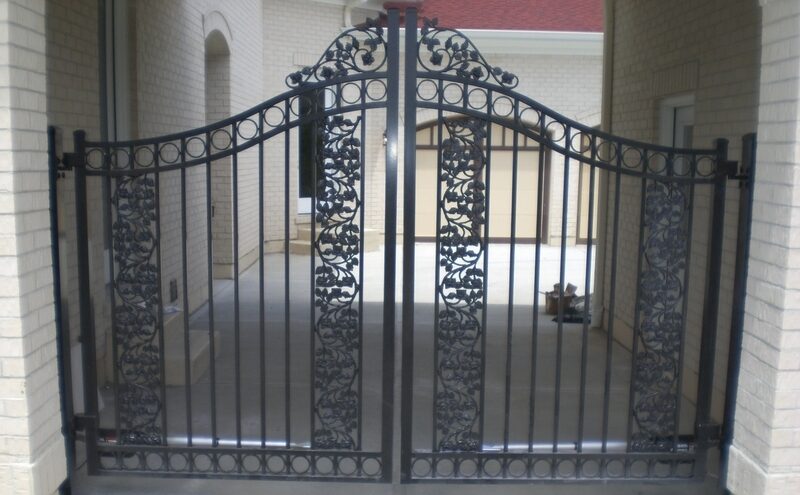 Ornate black metal swing gate installed with an electric opener system