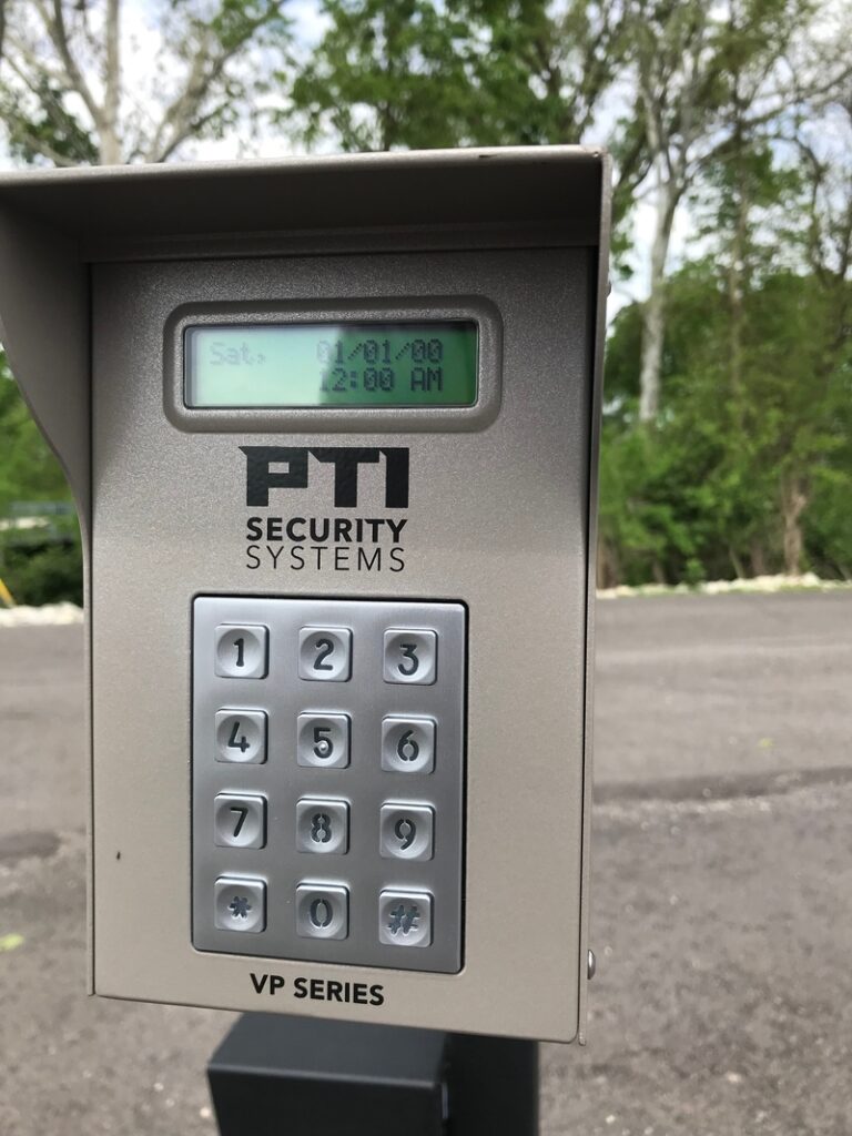 Close-up of an automatic gate keypad with a digital display and numbered keys