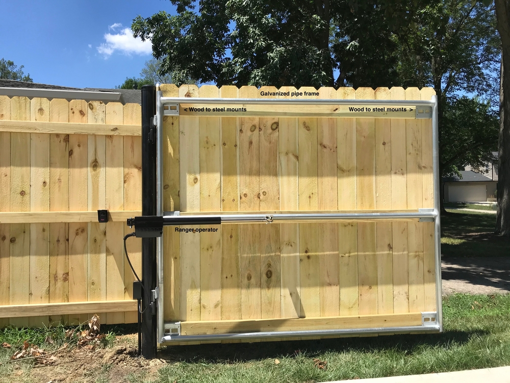 Hydraulic lift gate operator mounted on a wooden gate for reliable control