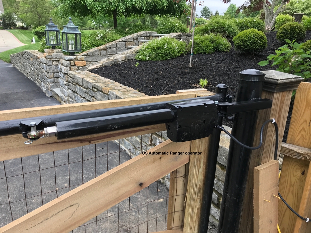 Close-up of an automatic gate operator with a hydraulic lift arm
