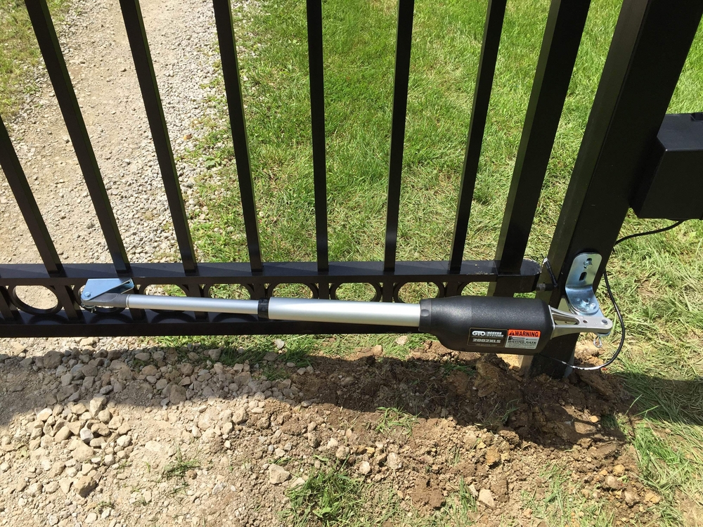 Close-up of an automatic swing gate with installed opener mechanism