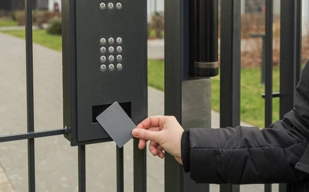Person using key fob card at secure gate keypad access system